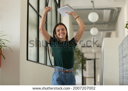Happy excited student celebrating success, passed exam, high test grade, good result. Millennial girl feeling joy, dancing in office corridor. Candidate getting hired after successful job interview Royalty-Free Stock Photo #2007207002