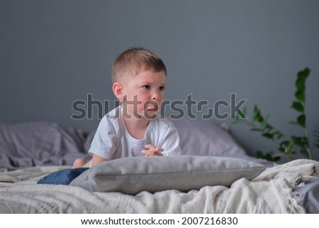 Sad child. Sulky little boy lying on the bed on arms. concept of three years crisis. Royalty-Free Stock Photo #2007216830