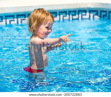 smiling cute  baby girl swims  in the pool in  summer