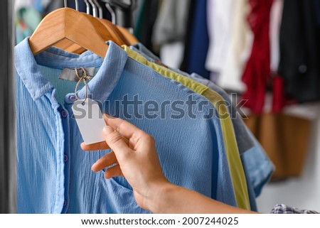Female hand and blank paper label on shirt
