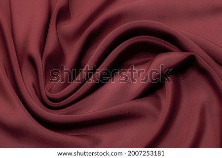 Abstract background texture of natural red color fabric. Fabric texture of natural cotton or linen, silk or satin, wool or jersey textile material. Luxurious red canvas background.
 Royalty-Free Stock Photo #2007253181