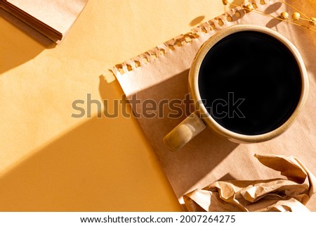 Flat lay of coffee cup and paper on bright sunny background. Creative work concept, summer morning at work. Workspace