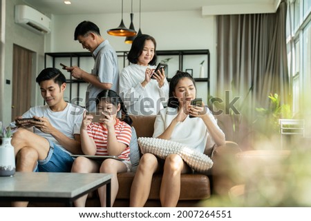 5G Technology for Families concept.Everyone sitting in sofa and using digital devices in living room.Big family grandmother grandfather and kids spending time together at home. Royalty-Free Stock Photo #2007264551