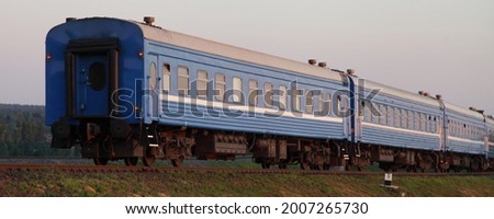 Old blue passenger train last wagon at sunny summer evening Royalty-Free Stock Photo #2007265730