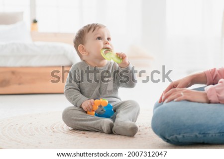 Small little kid child toddler infant newborn baby gnawing toy ring. Teething process, milk baby teeth tooth concept. Playing games with child. Babycare and motherhood Royalty-Free Stock Photo #2007312047