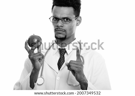 Studio shot of young handsome bearded African man doctor isolated against white background in black and white