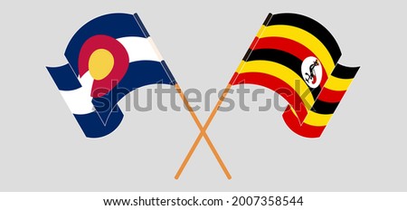 Crossed and waving flags of The State of Colorado and Uganda