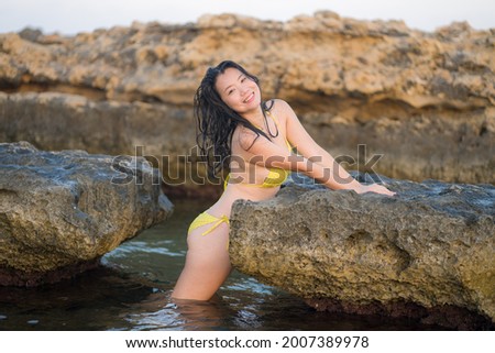 young happy and attractive Asian woman in the sea - cheerful and carefree Korean girl playful in the water during Summer holidays trip in beautiful tropical island