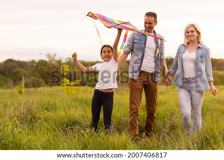 Happy family: mother, father, child daughter on nature on sunset.