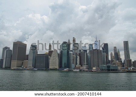 A stunning view of Manhattan skyline across river hudson with dramatic rain clouds in the sky