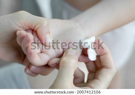 The woman is trying to pull the splinter out of the child's hand. A splinter in a child's hand Royalty-Free Stock Photo #2007412106