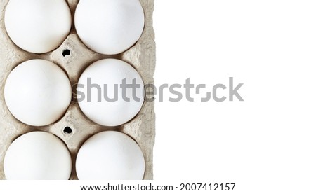 Six white eggs placed in a carton box isolated on a white background. Top view. Closeup. Copy space.