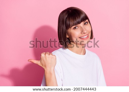 Portrait of attractive cheerful girl showing solution ad advert copy space isolated over pink pastel color background