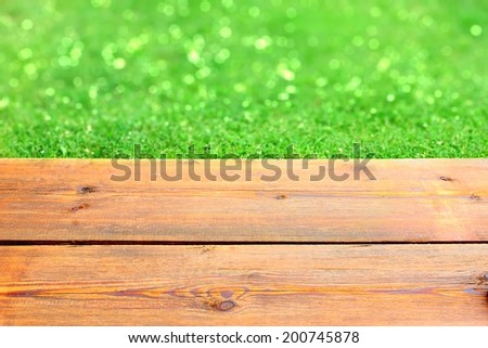 Wooden Terrace and Green Bokeh Background, with space for text or image.