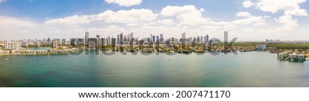 Panoramic view of the miami beach coastline with buildings, trees, yachts and a blue sky