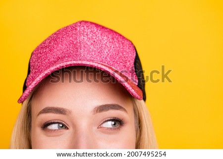 Cropped photo portrait woman in cap cunning looking empty space isolated vibrant yellow color background Royalty-Free Stock Photo #2007495254
