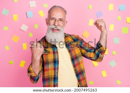 Photo of pretty lucky mature man dressed checkered shirt rising fists finally finding solution isolated pink stickers color background