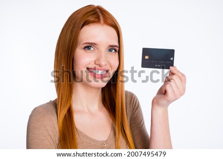 Photo of adorable cute ginger lady wear beige shirt smiling holding credit card isolated white color background