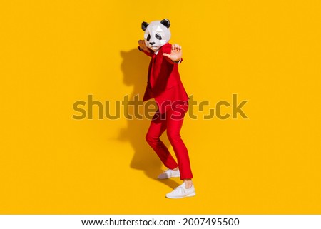 Photo of panda guy crazy party funny dance wear mask red tux tie shoes isolated on yellow color background