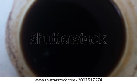 abstract defocused background from black coffee in a white glass which is photographed at a very close distance