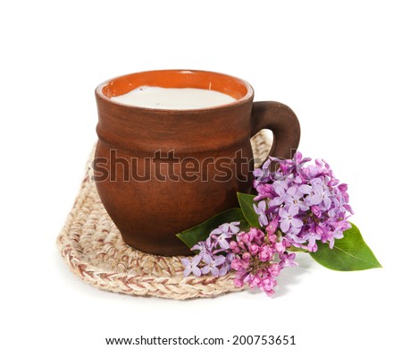 natural fresh milk in a ceramic cup and lilac isolated on a white