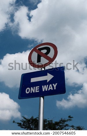 multiple sign road says no parking and one way direction