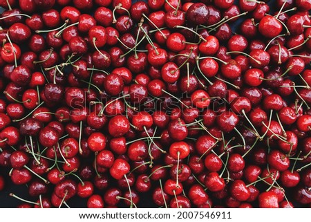 Flat lay background with heap of fresh red sweet cherry. Eco farm food cultivation. Healthy eating lifestyle concept. High quality photo