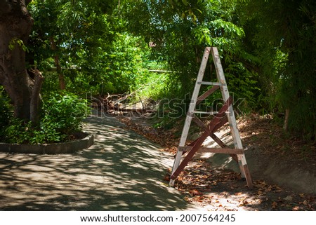 A style ladder in garden with copy space text, Aluminum stairs repaired with wood