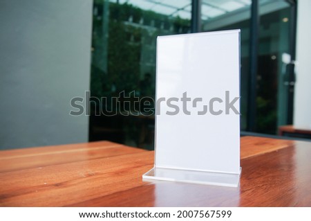 Mock up Menu frame. standing on wood table in Bar restaurant cafe. space for text. Menu mack up blank for text marketing promotion.