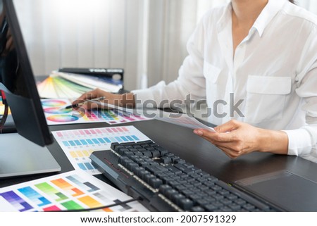 creative graphic designer choosing color scale for editing artwork while working in office