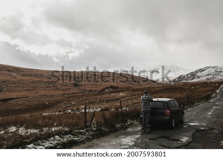 Man taking pictures of snowy mountains