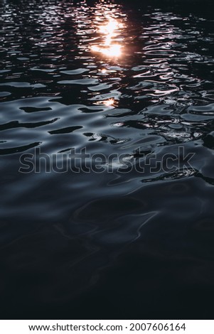 Dark blue sea water on the shore with sunset light