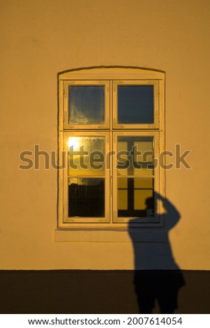 Hirtshals, Denmark The shadow of a photographer in the window of an old house.