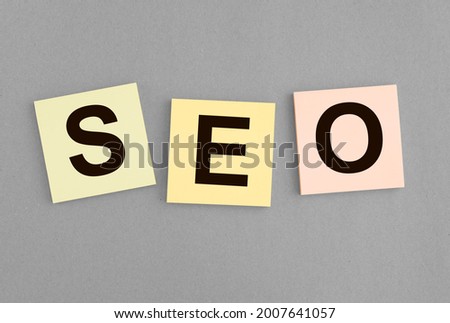 SEO acronym word on paper notes on gray background.