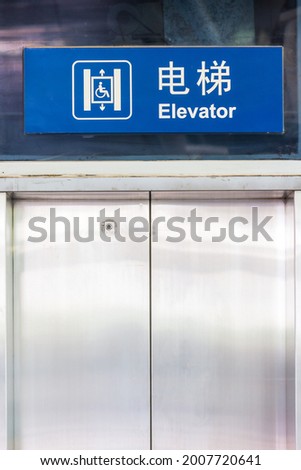 Elevator sign and text in both Chinese and English where the Chinese character means 'Elevator'