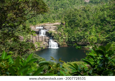 Gorgeous waterfall with two falls in the middle of  Iriomote island forest. Amazing natural pool, tropical vegetation around. Iriomote Island. Royalty-Free Stock Photo #2007728531