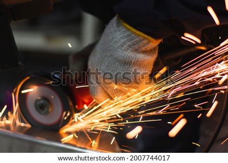 Metal workers use manual labor. Technicians use steel cutting tools to cut steel. Metal cutting. content work safety. builder wear fireproof gloves for safety at work. Royalty-Free Stock Photo #2007744017