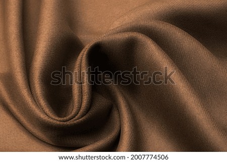 Abstract texture of natural beige or brown color fabric as concept background. Fabric texture of natural cotton or linen, silk or satin, wool or jersey textile material. Luxurious dark background.
 Royalty-Free Stock Photo #2007774506