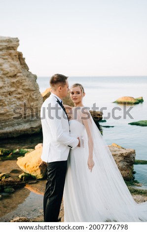 Wedding photo of a couple in love on the seashore at sunrise.