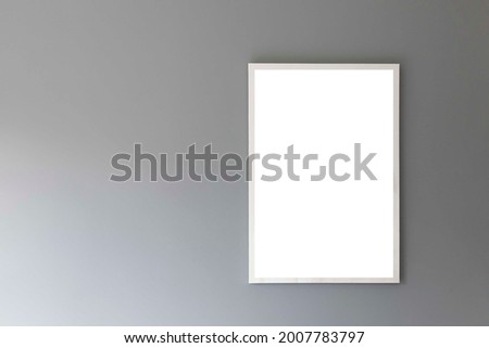 Blank white photo frame on a smooth gray wall