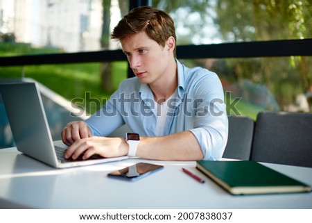 Skilled male programmer updating software settings on modern netbook technology using 4g internet indoors, Caucasian student e learning on laptop computer connecting to wireless for online browsing