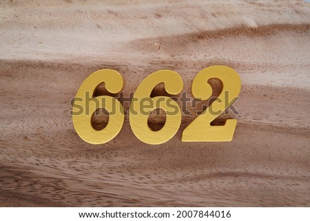Gold numerals 662 on a dark brown to off-white wood pattern background.