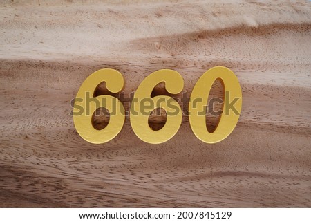 Gold numerals 660 on a dark brown to off-white wood pattern background.