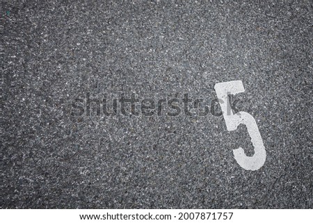 white painted number five on the asphalt