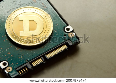 Dogecoin crypto currency replica coin on small personal computer harddisk drive on the marble floor with empty copy space for text
