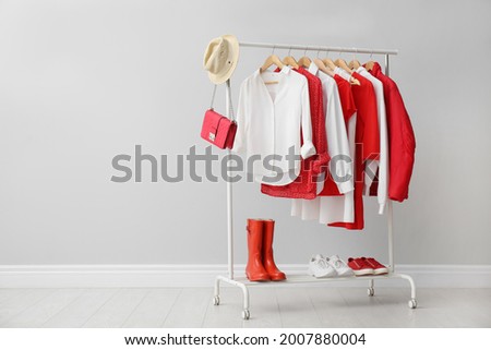 Rack with bright stylish clothes, shoes and accessories near light grey wall indoors, space for text Royalty-Free Stock Photo #2007880004