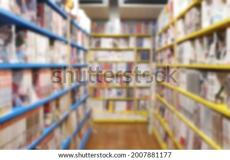 blurred view of interior of manga or comic book store showing many books displayed on books shelves. 