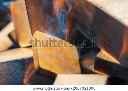 lighting a fire, flame, a warm fireplace with lots of trees ready for barbecue, burning firewood, wood. Selective focus. Close view. The concept of fire, burning