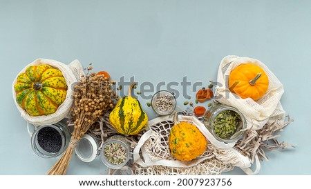 Zero waste healthy food pumpkin, seeds, vegetables, dried fruits flat lay on blue background. Groceries in textile bags,glass jars. Eco friendly plastic free low waste lifestyle.