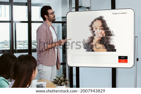 Selective focus on casual handsome business Caucasian man presenting and online meeting via trouble conference with bad connection and noise problem picture on screen Royalty-Free Stock Photo #2007943829